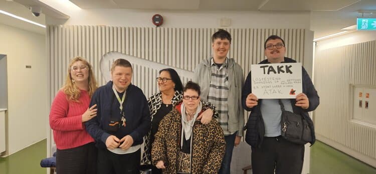 Fimm félagar í Átaki standa saman og halda á TAKK skilti um réttindi fatlaðs fólks
