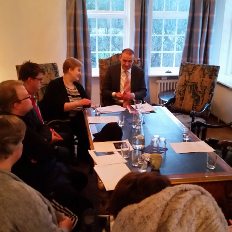 Aileen afhentir forseta kenslubók í auðlesnum texta.